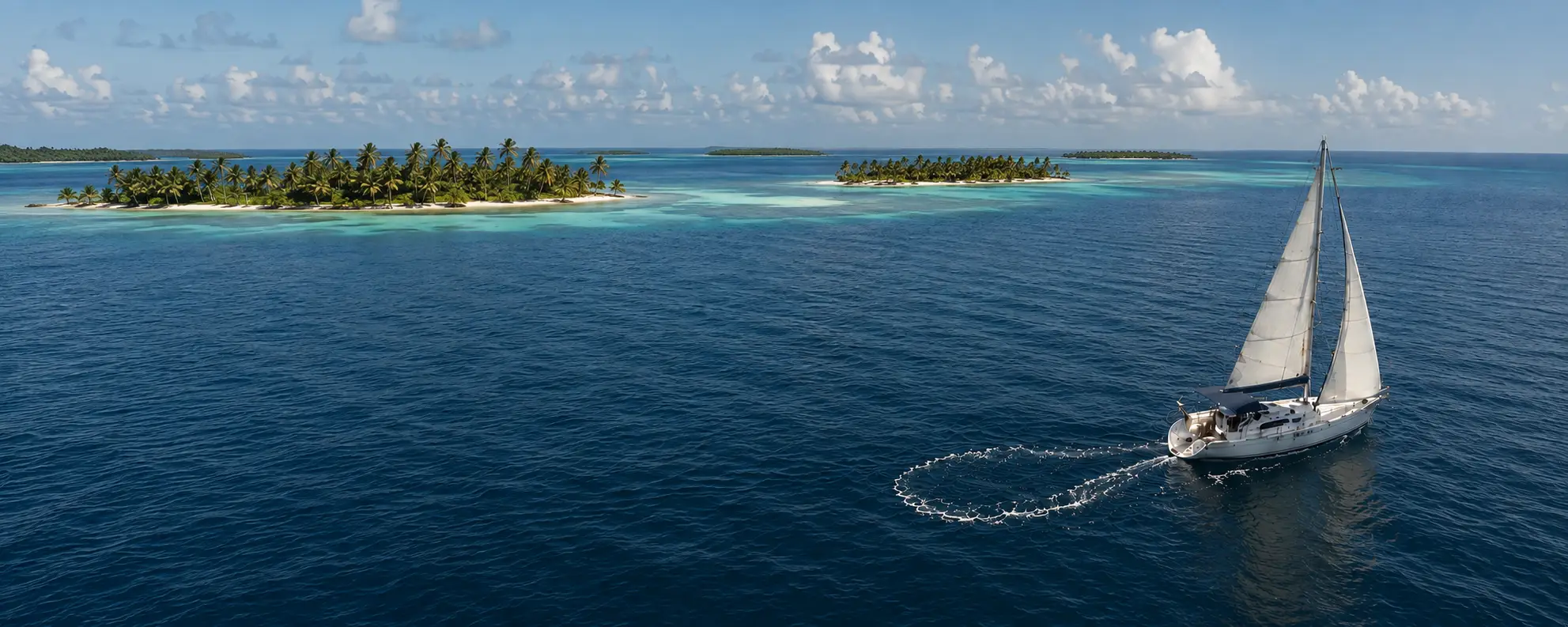 Velero fondeado con personas a bordo frente a una isla tropical.